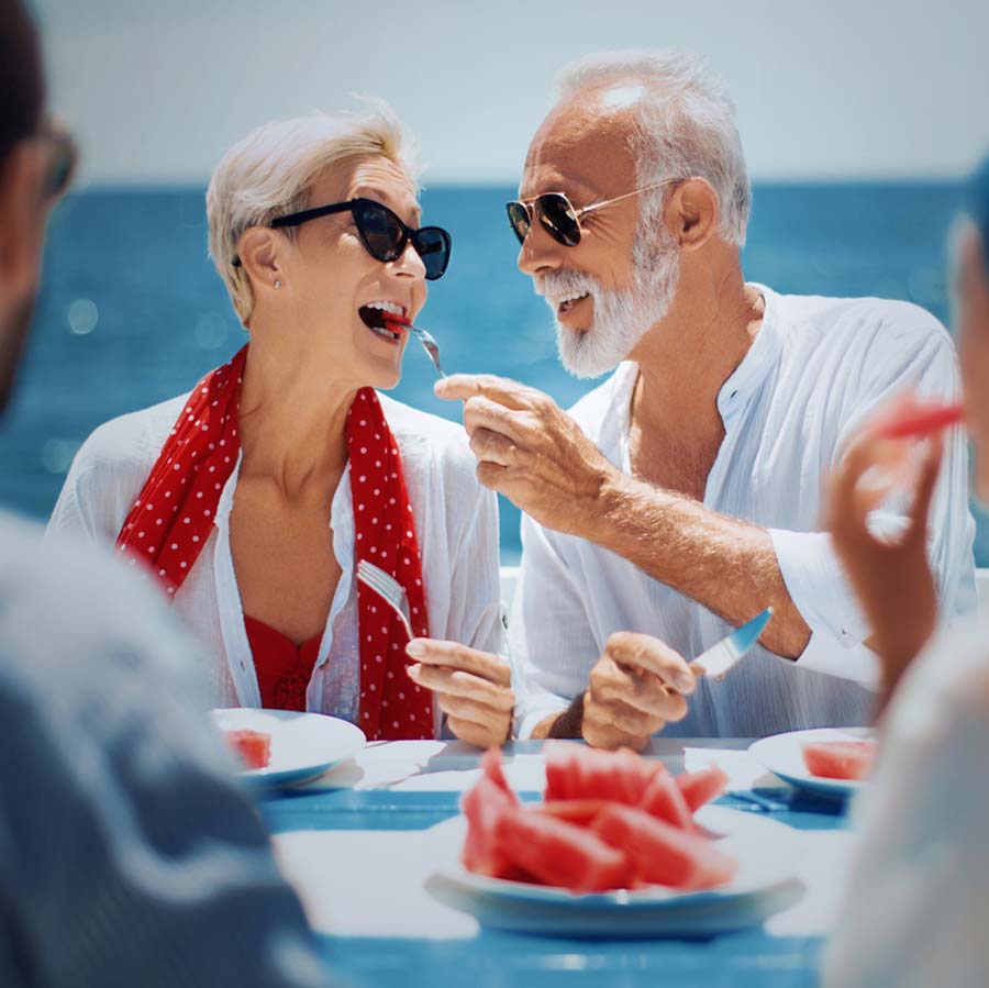 couple feeding each other by the sea